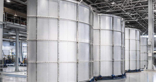 Curved aluminum-lithium alloy fuselage barrel panels inside an aerospace factory
