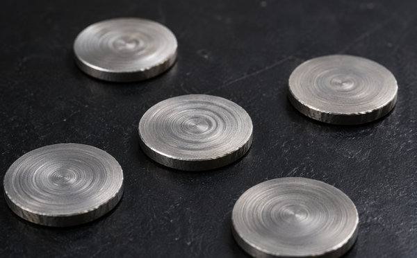 Small metallic discs processed by high-pressure torsion on a dark surface