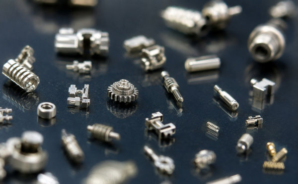 Tiny precision micro-formed metal gears and pins in macro view