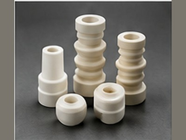 Stacked ceramic insulating components with flanged and stepped profiles.