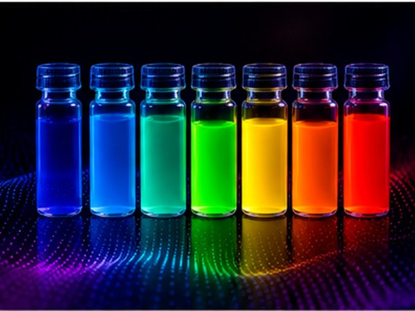 Seven illuminated vials show water-based quantum dot solutions emitting a sequence of visible colors.