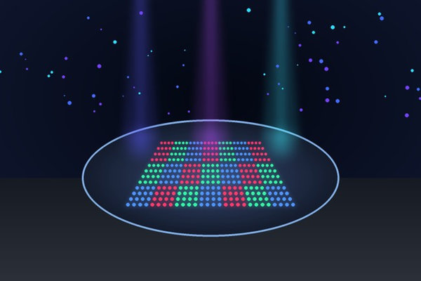 Ultraviolet beams illuminate a circular wafer carrying a multicolor grid of nanoscale emissive sites.