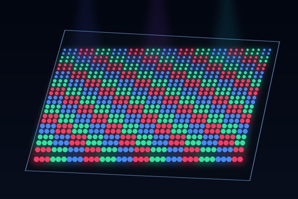 A tilted dark substrate is covered with orderly red, green, and blue luminous micro-pixels.