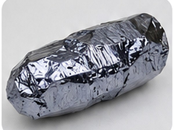 Reflective rod-like polycrystalline silicon sample with faceted surfaces on a neutral background.