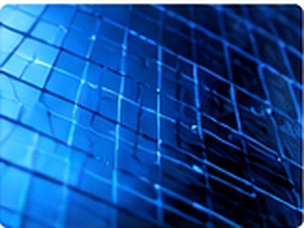 Blue photovoltaic cell surfaces arranged in a repeating grid under cool lighting.