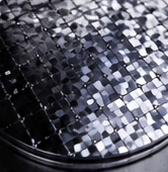 Reflective crystalline silicon pieces form a dense mosaic inside a laboratory dish.